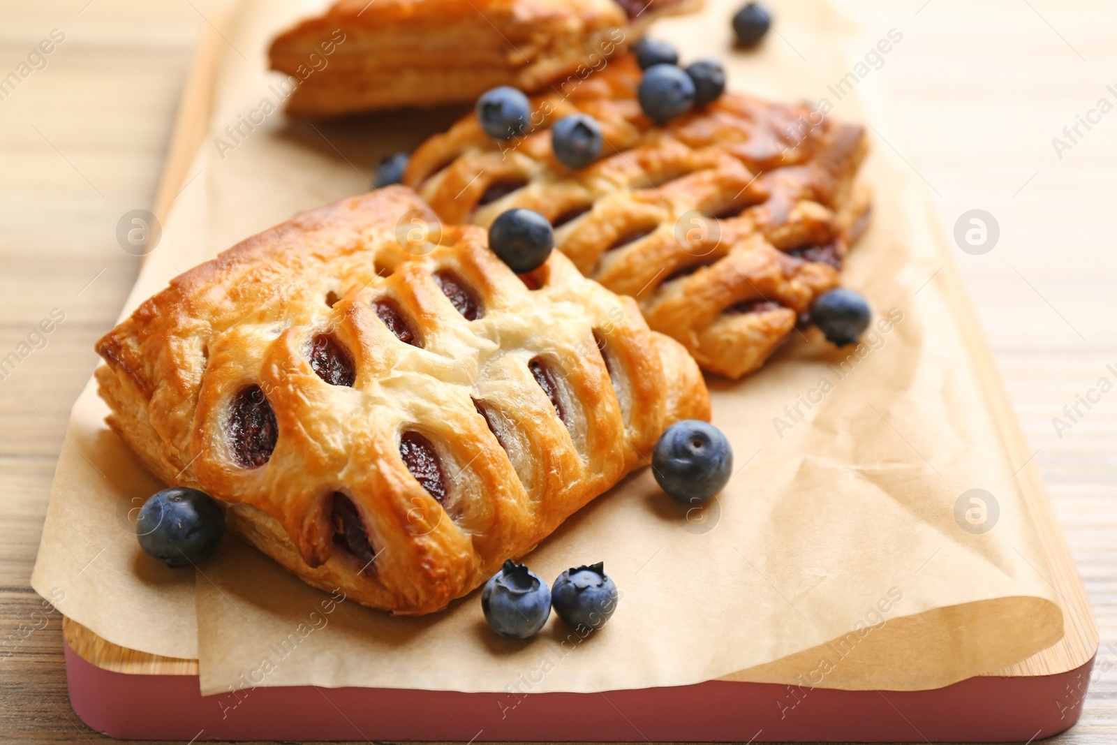 Photo of Fresh delicious puff pastry with fresh berries on table, closeup