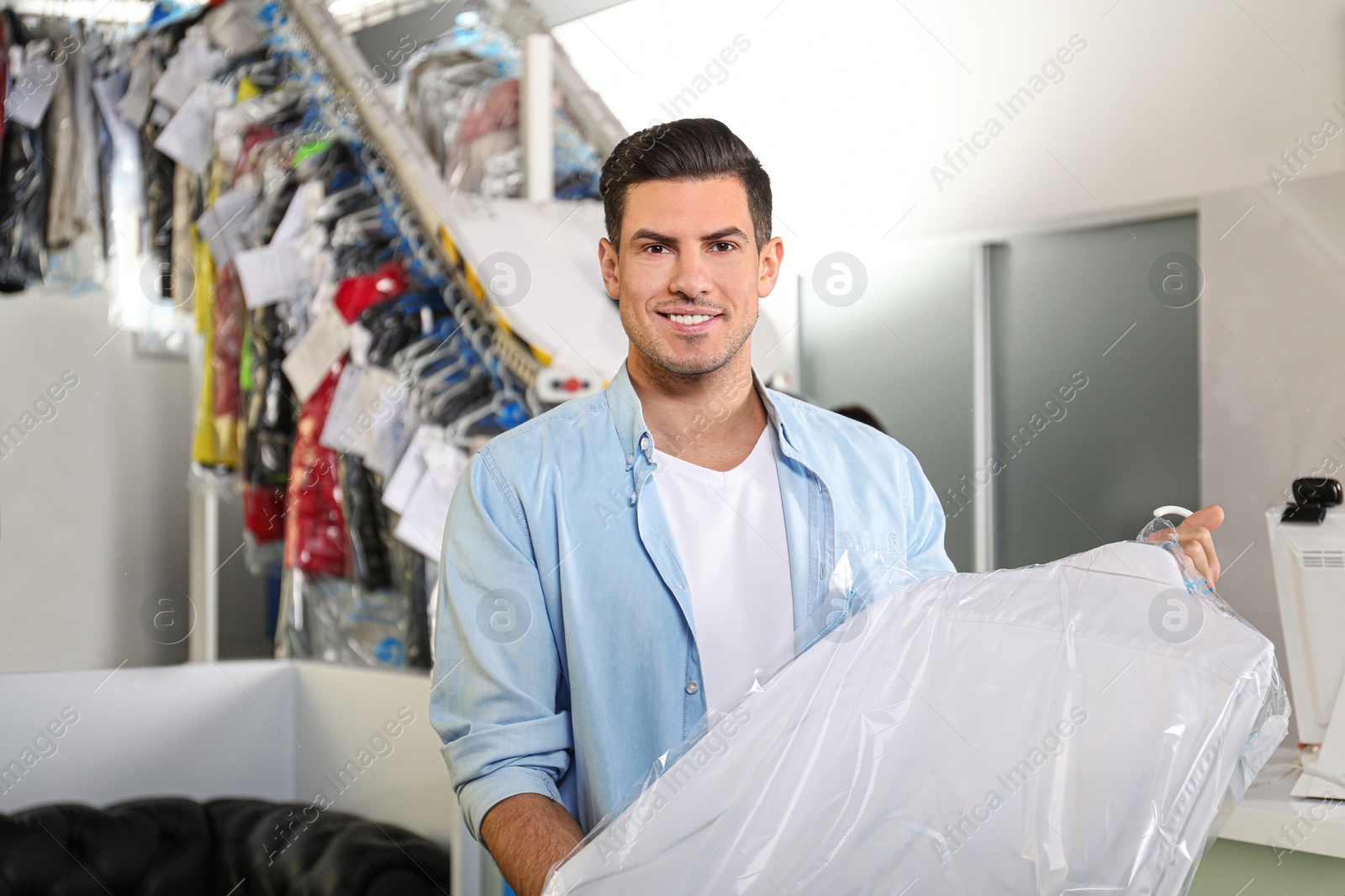 Photo of Happy client with shirt at modern dry-cleaner's