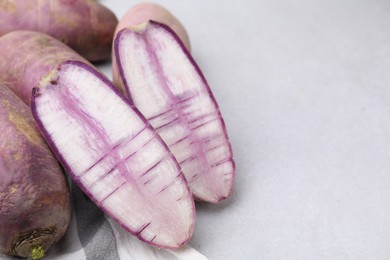 Purple daikon radishes on light grey table, closeup. Space for text