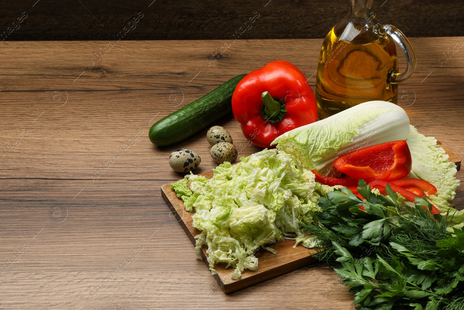 Photo of Chinese cabbage and different products on wooden table, space for text