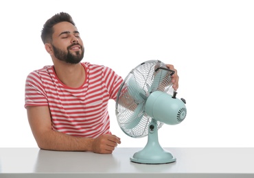 Man enjoying air flow from fan on white background. Summer heat