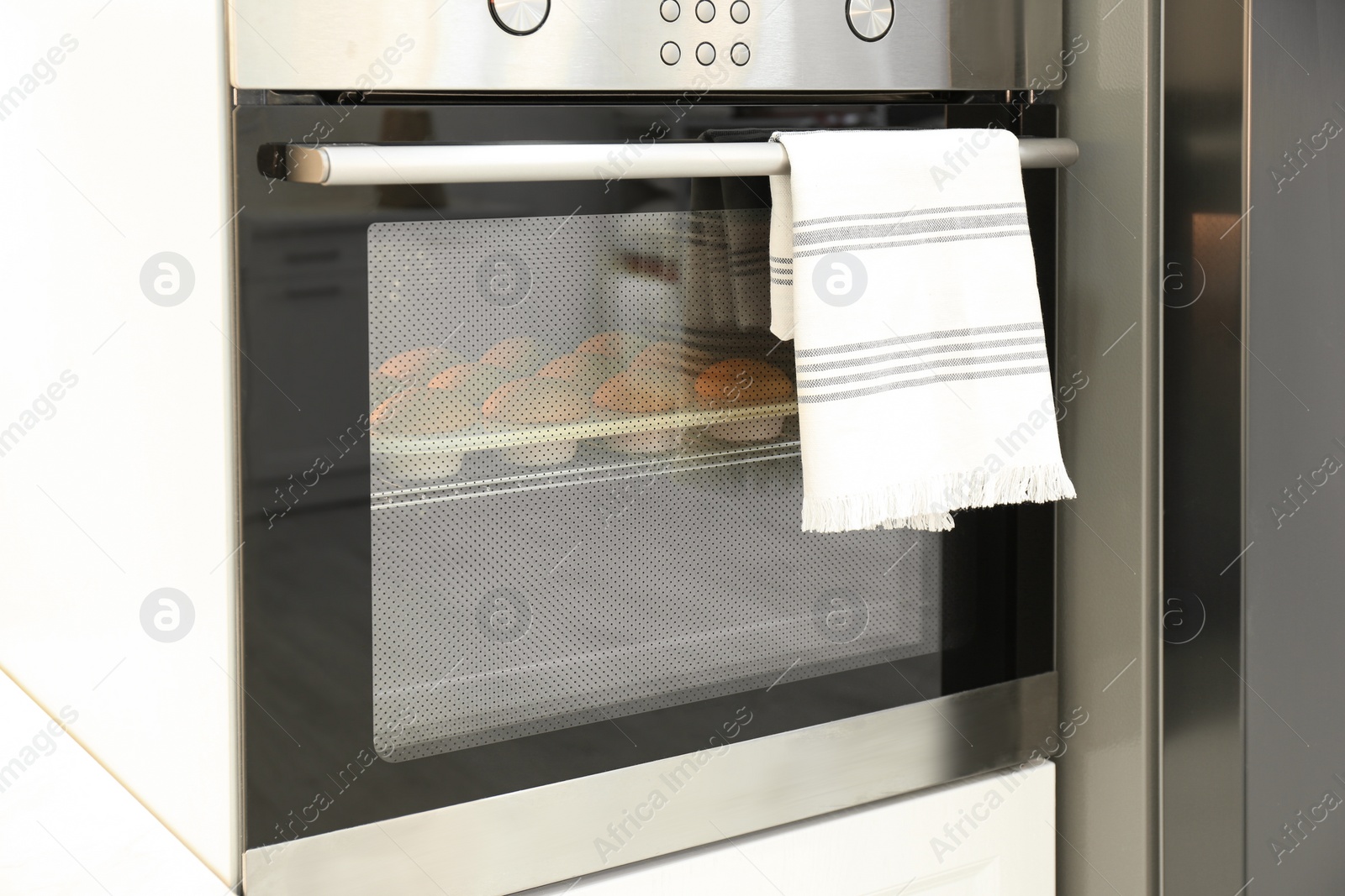 Photo of Baking pan with cupcakes in modern oven