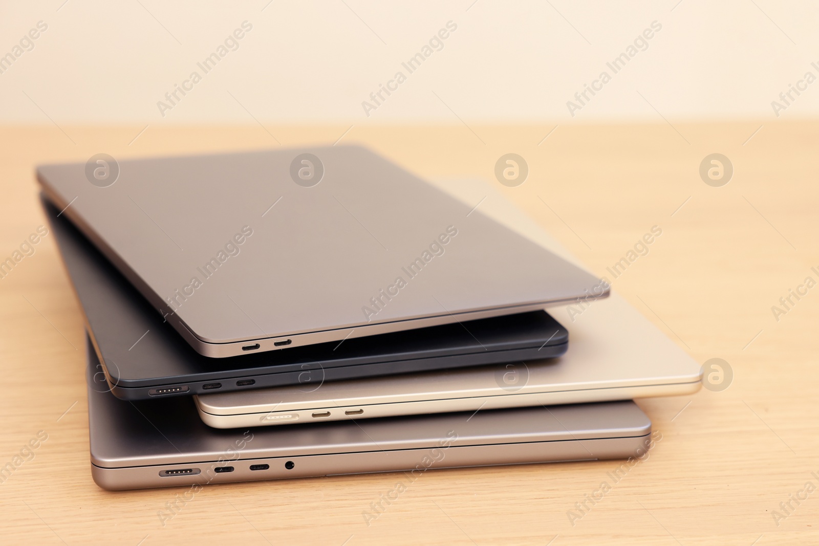 Photo of Different modern laptops on wooden table, closeup