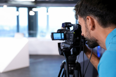 Professional video camera operator working in studio, closeup