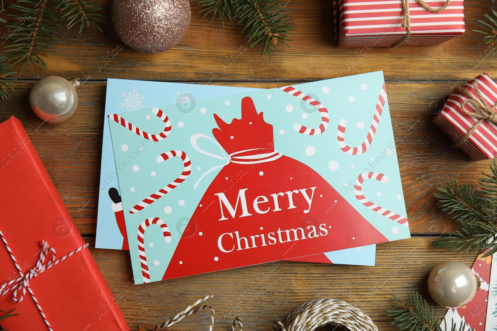 Photo of Flat lay composition with Christmas cards and festive decor on wooden background