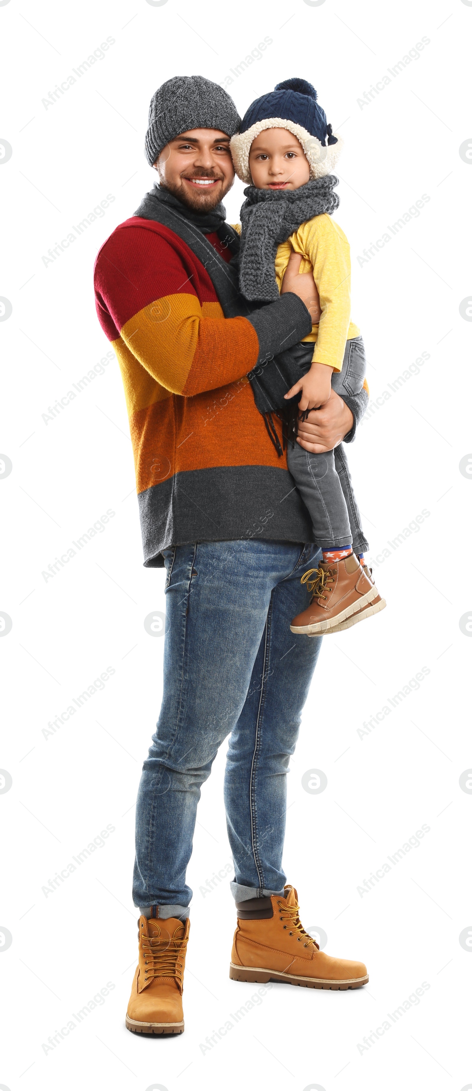 Photo of Happy father and son in warm clothes on white background. Winter vacation