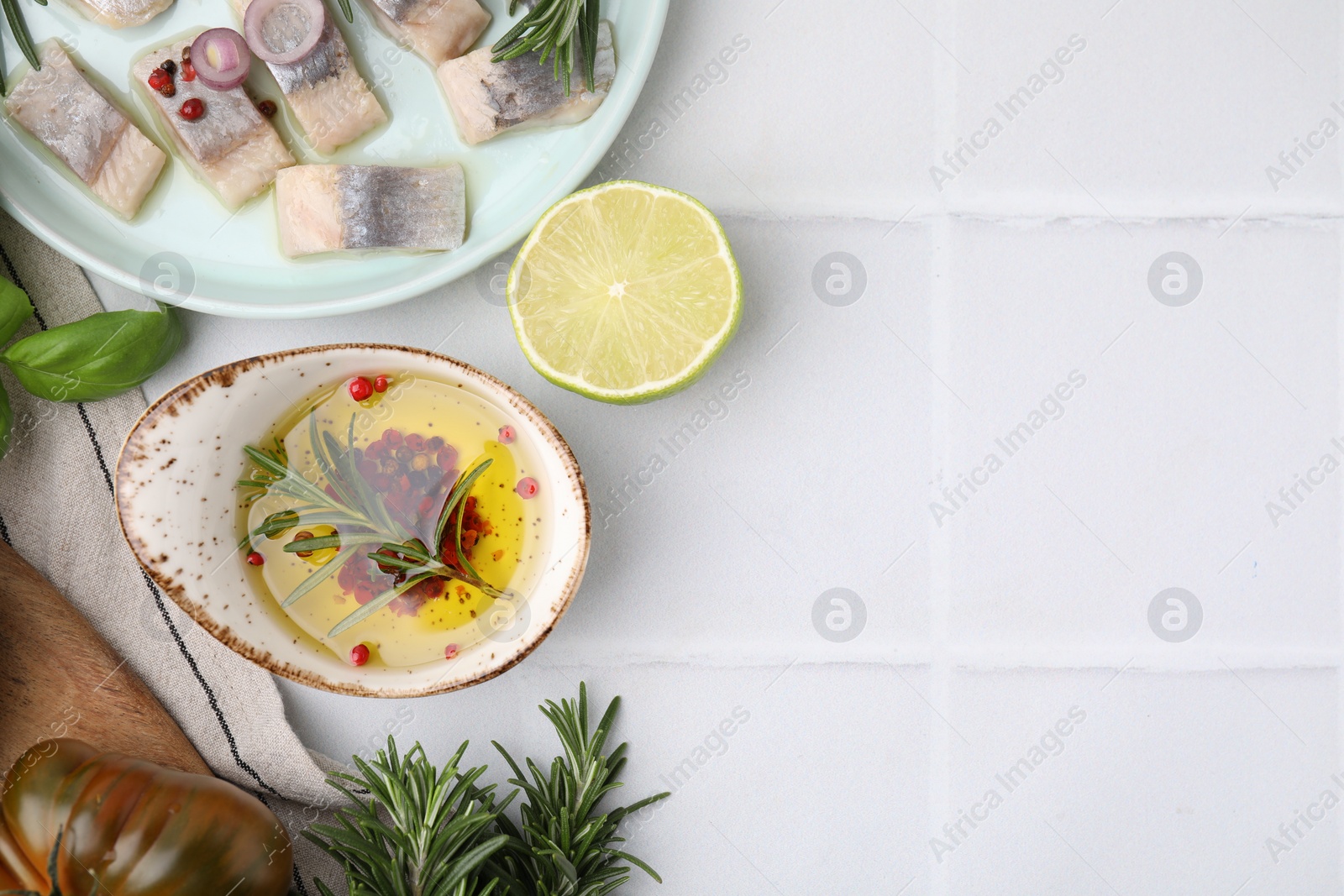 Photo of Tasty fish marinade with rosemary and products on light tiled table, flat lay. Space for text