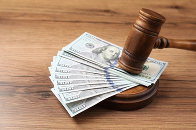 Judge's gavel and money on wooden table