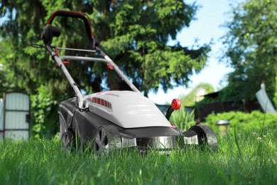 Lawn mower on green grass in garden, low angle view