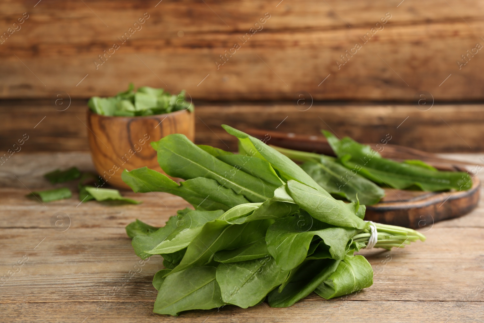Photo of Fresh green sorrel leaves on wooden table, closeup