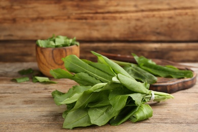 Fresh green sorrel leaves on wooden table, closeup