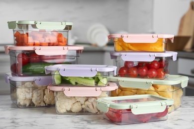 Boxes with fresh raw vegetables on table in kitchen