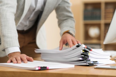 Businessman working at wooden table in office, closeup of hands