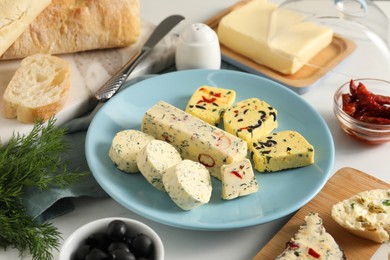 Photo of Different types of tasty butter served on white table