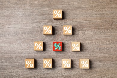 Best mortgage interest rate. Red cube with percent sign among others on wooden table, flat lay
