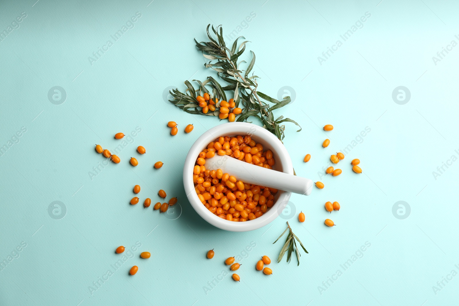 Photo of Fresh ripe sea buckthorn on light blue background, flat lay