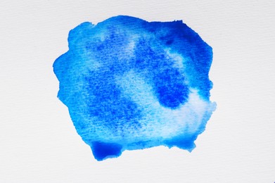 Photo of Blot of light blue ink on white background, top view