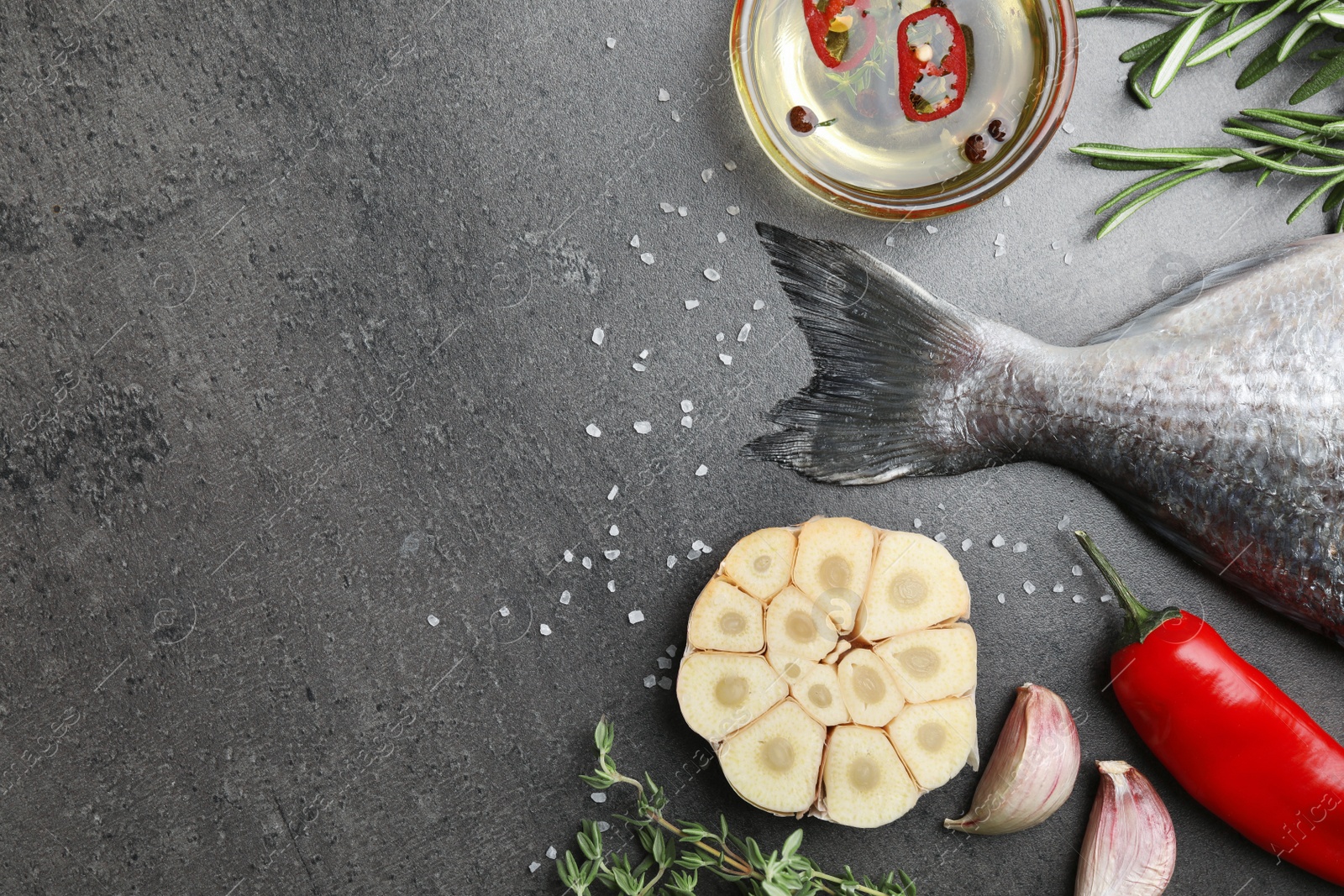 Photo of Fresh dorado fish and ingredients on grey table, flat lay. Space for text