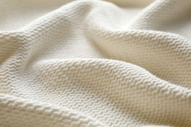 Beautiful white knitted fabric as background, closeup