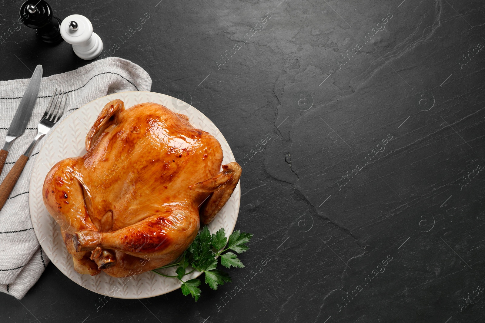 Photo of Tasty roasted chicken served on grey textured table, flat lay. Space for text