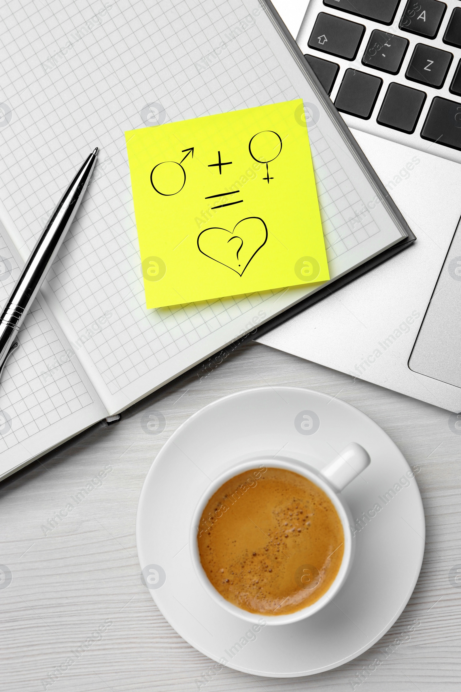 Image of Sex Education. Note with drawing in notebook, laptop and cup of coffee on white wooden table, flat lay. Male and female gender signs equal heart with question mark