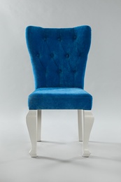 Photo of Stylish blue chair on light grey background. Element of interior design