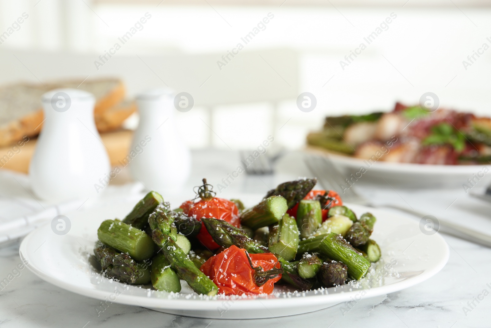 Photo of Oven baked asparagus with cherry tomatoes on white plate