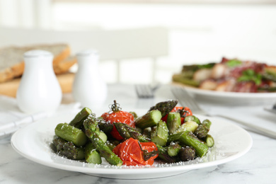 Photo of Oven baked asparagus with cherry tomatoes on white plate