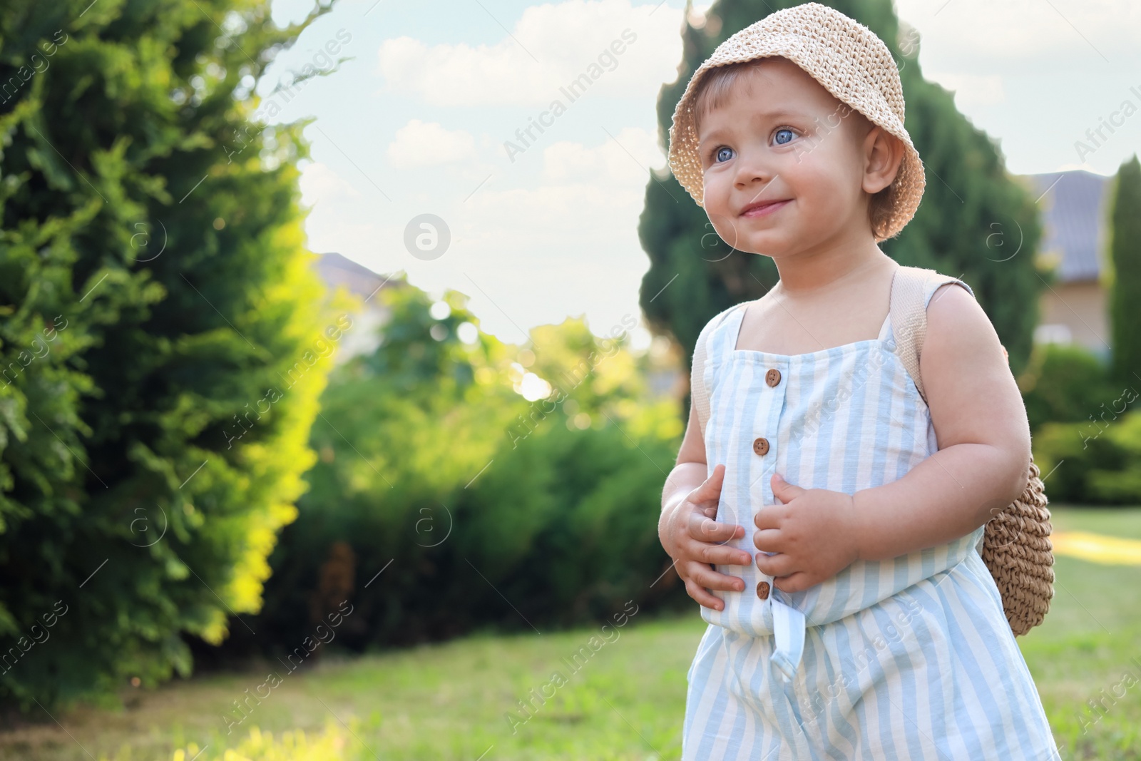 Photo of Cute little girl wearing stylish clothes outdoors on sunny day. Space for text