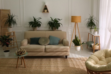 Photo of Stylish living room interior with comfortable sofa and cushions