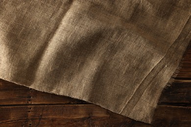 Photo of Burlap fabric on wooden table, top view