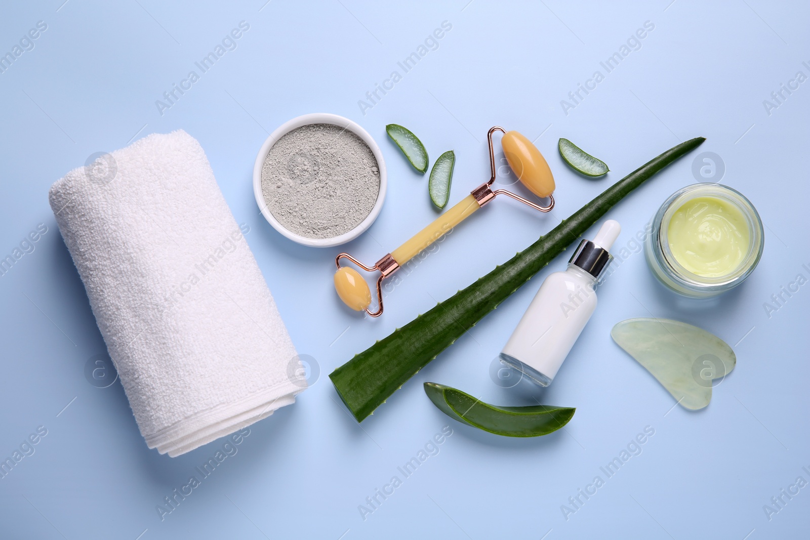 Photo of Flat lay composition with cosmetic products and cut aloe leaves on light blue background