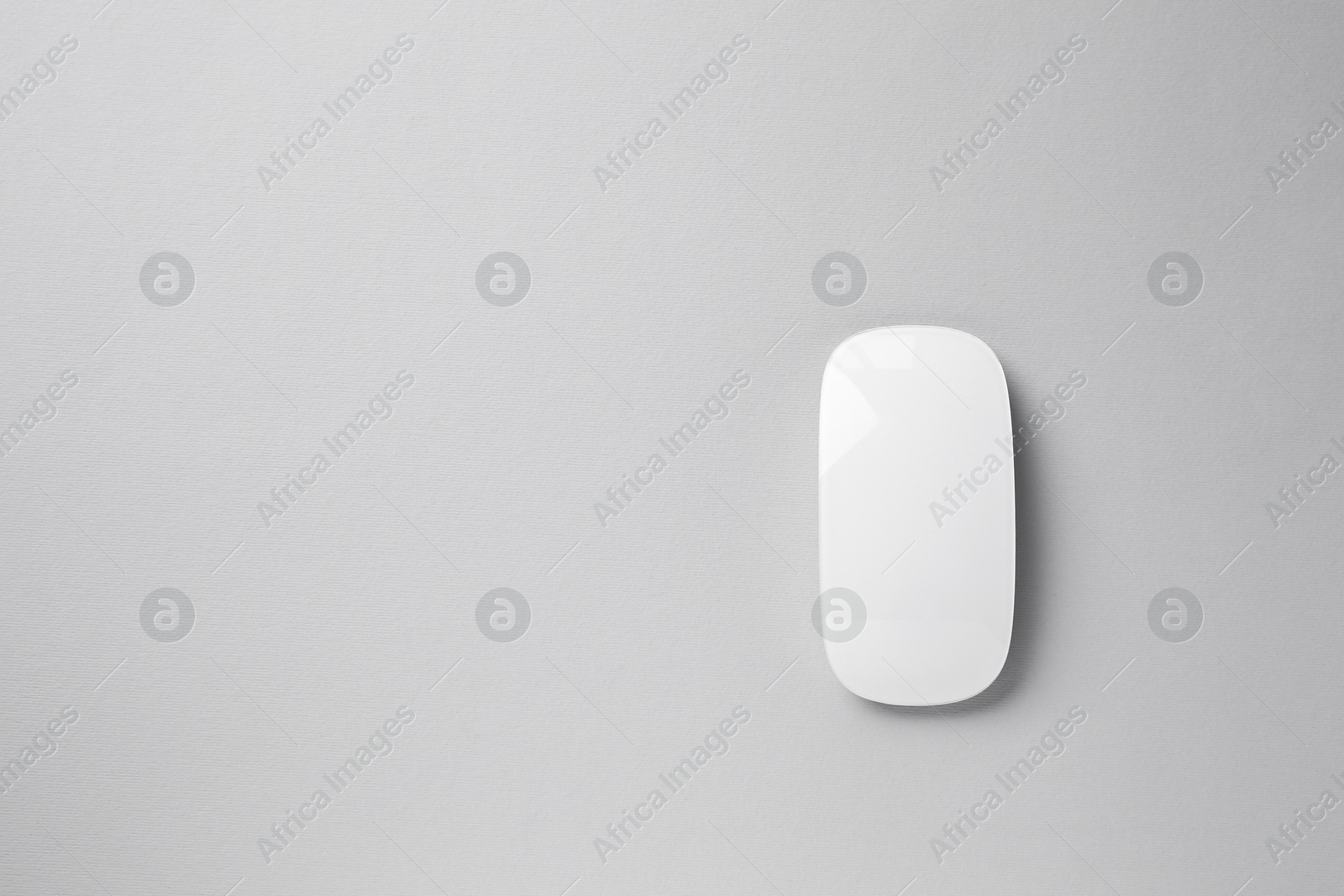 Photo of One wireless mouse on grey background, top view. Space for text