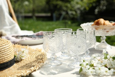 Photo of Beautiful table setting with spring flowers in garden on sunny day