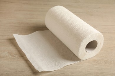 Photo of Roll of paper towels on wooden table, closeup