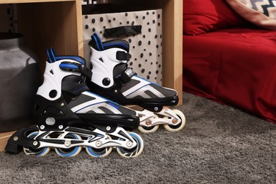 Photo of Stylish roller skates on gray rug in teenager's room