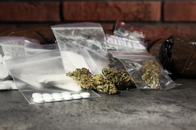 Hemp and other drugs in packages on grey  table