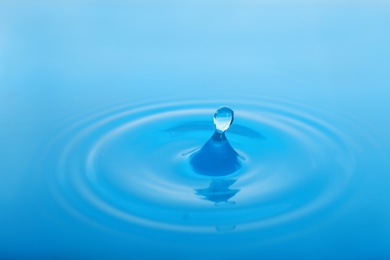 Photo of Splash of blue water with drop as background, closeup