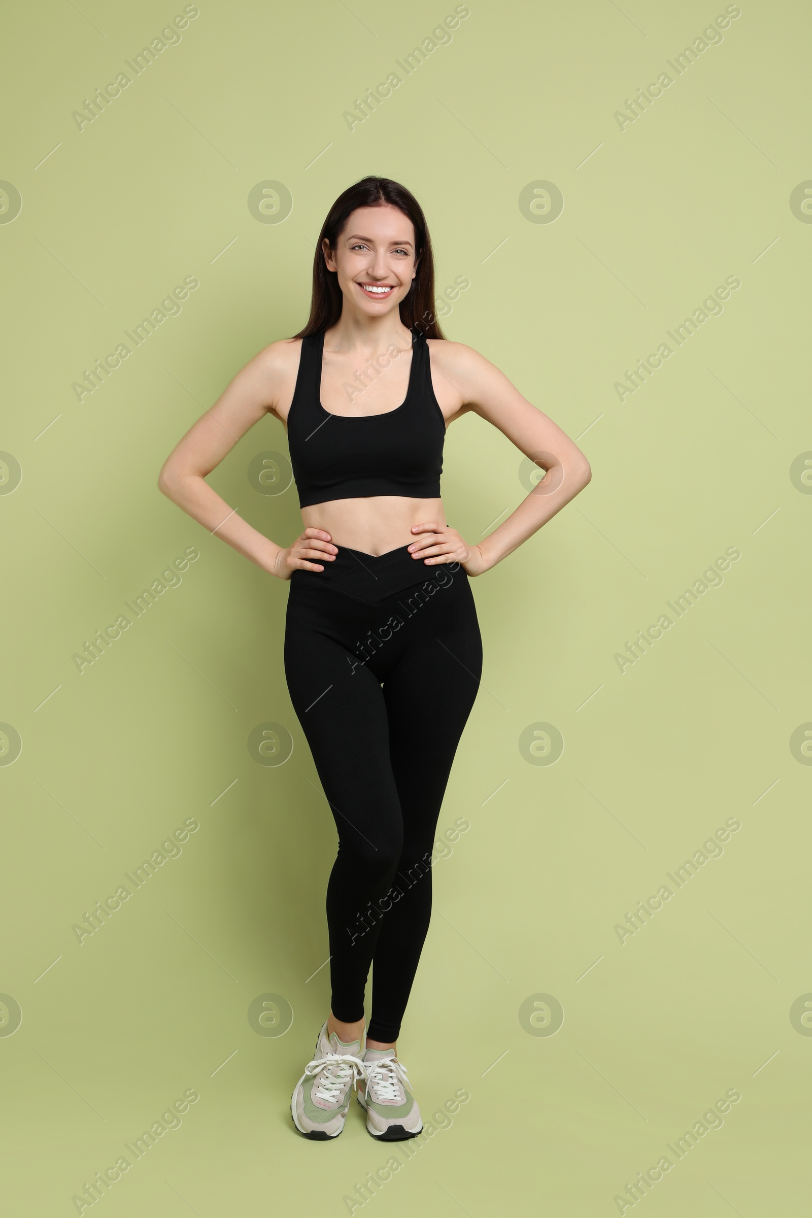 Photo of Happy young woman with slim body posing on green background