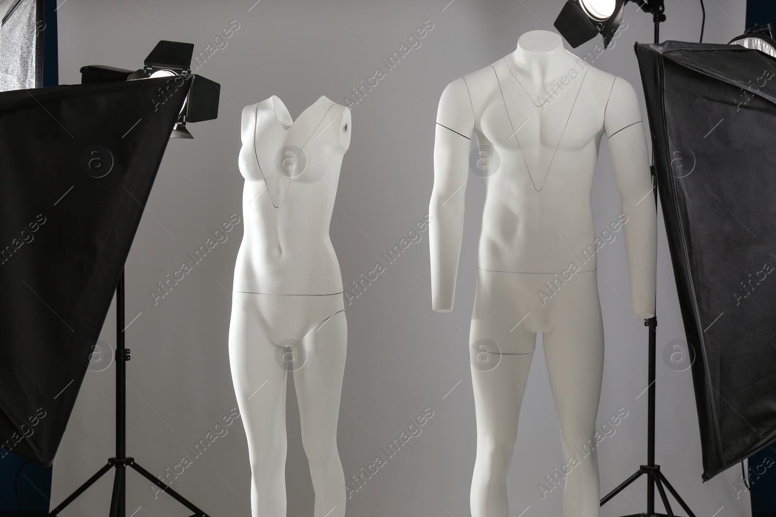 Photo of Ghost mannequins and professional lighting equipment in modern photo studio