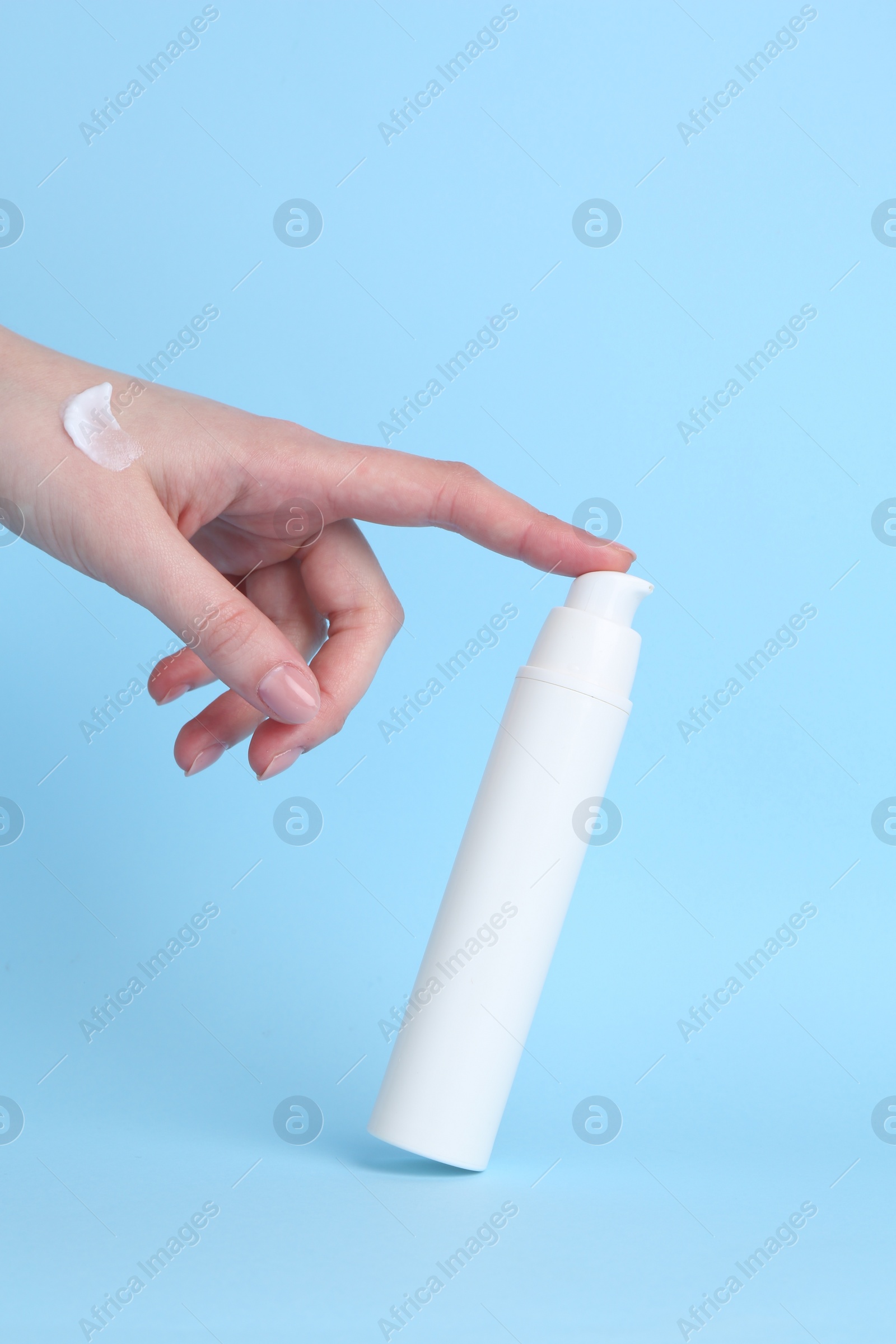 Photo of Woman with cream on light blue background, closeup