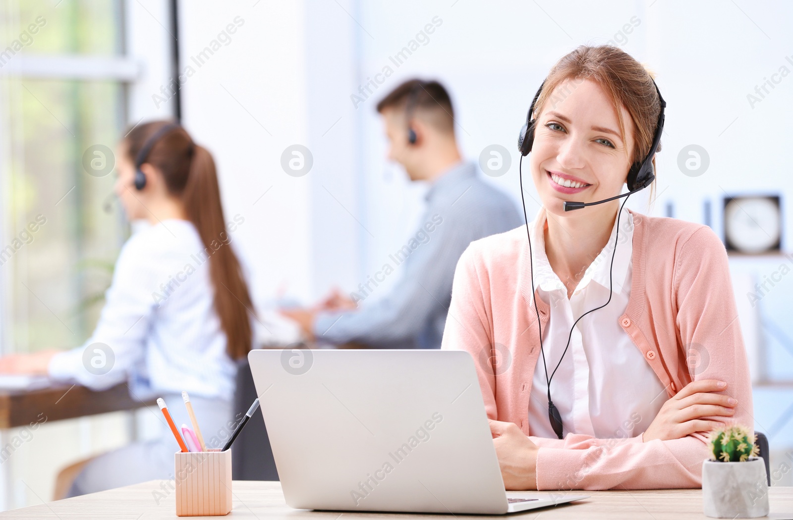 Photo of Female receptionist with headset at desk in office