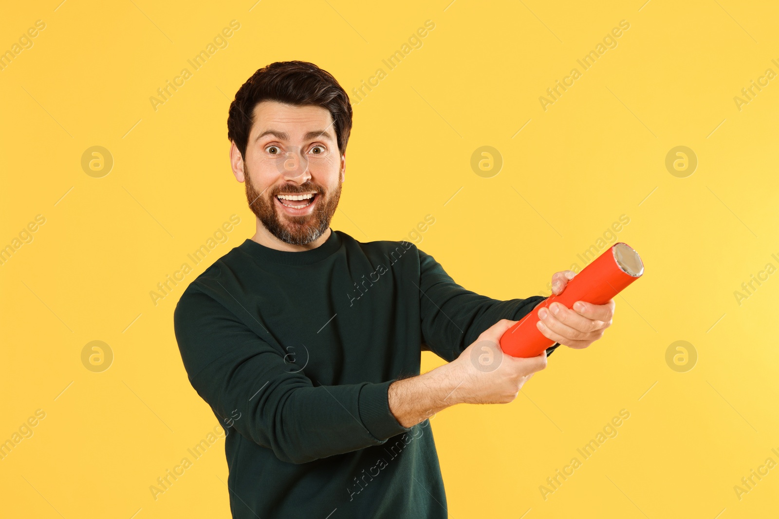 Photo of Emotional man with party popper on yellow background