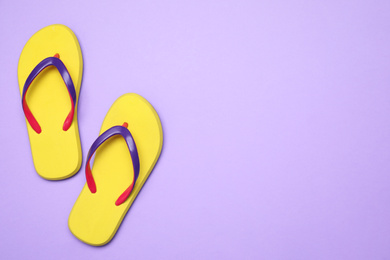 Photo of Pair of stylish flip flops on violet background, top view with space for text. Beach objects