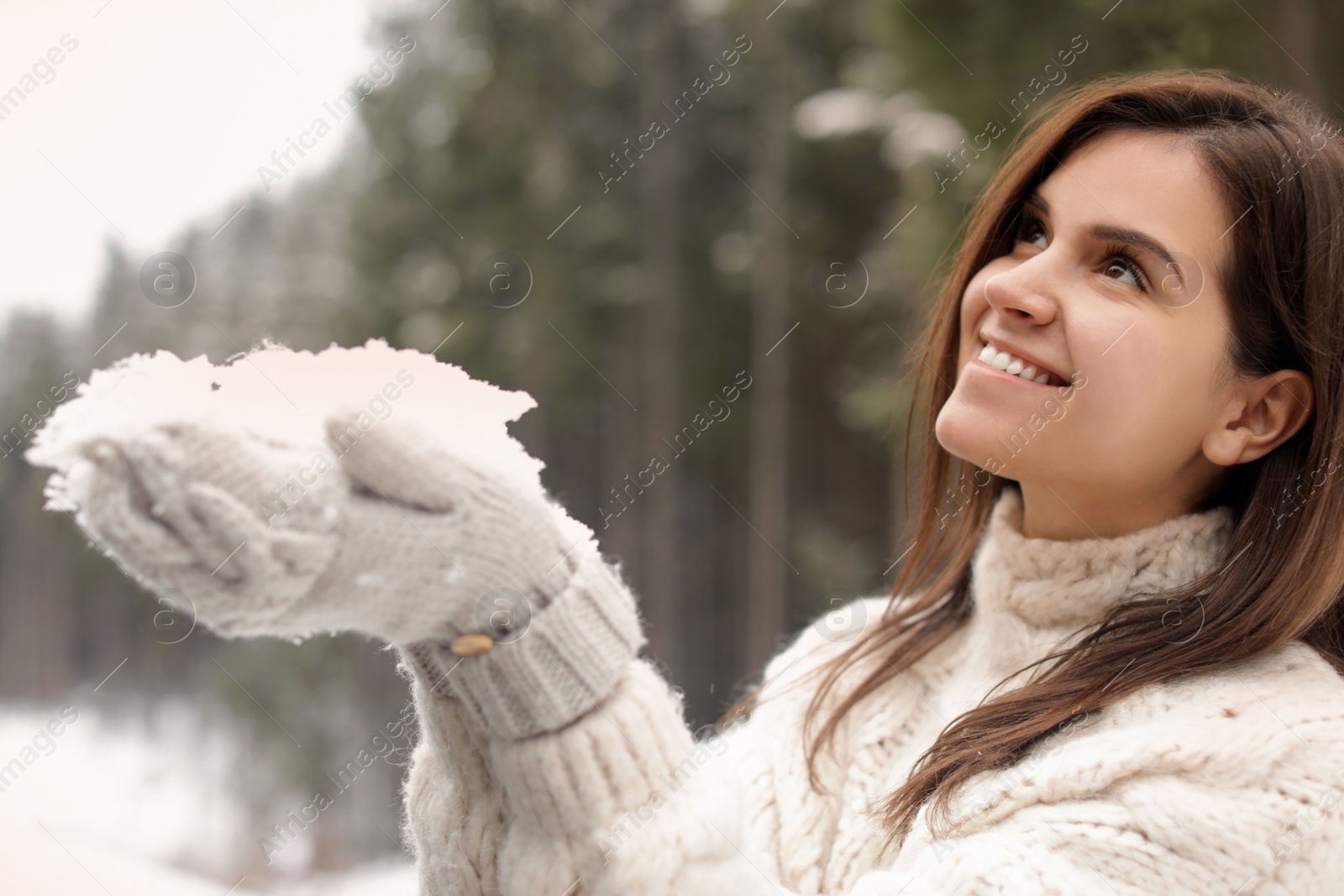 Photo of Young woman playing with snow outdoors. Winter vacation