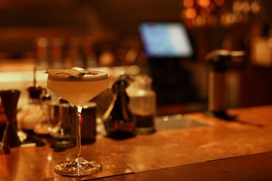 Photo of Fresh alcoholic cocktail on counter in bar. Space for text