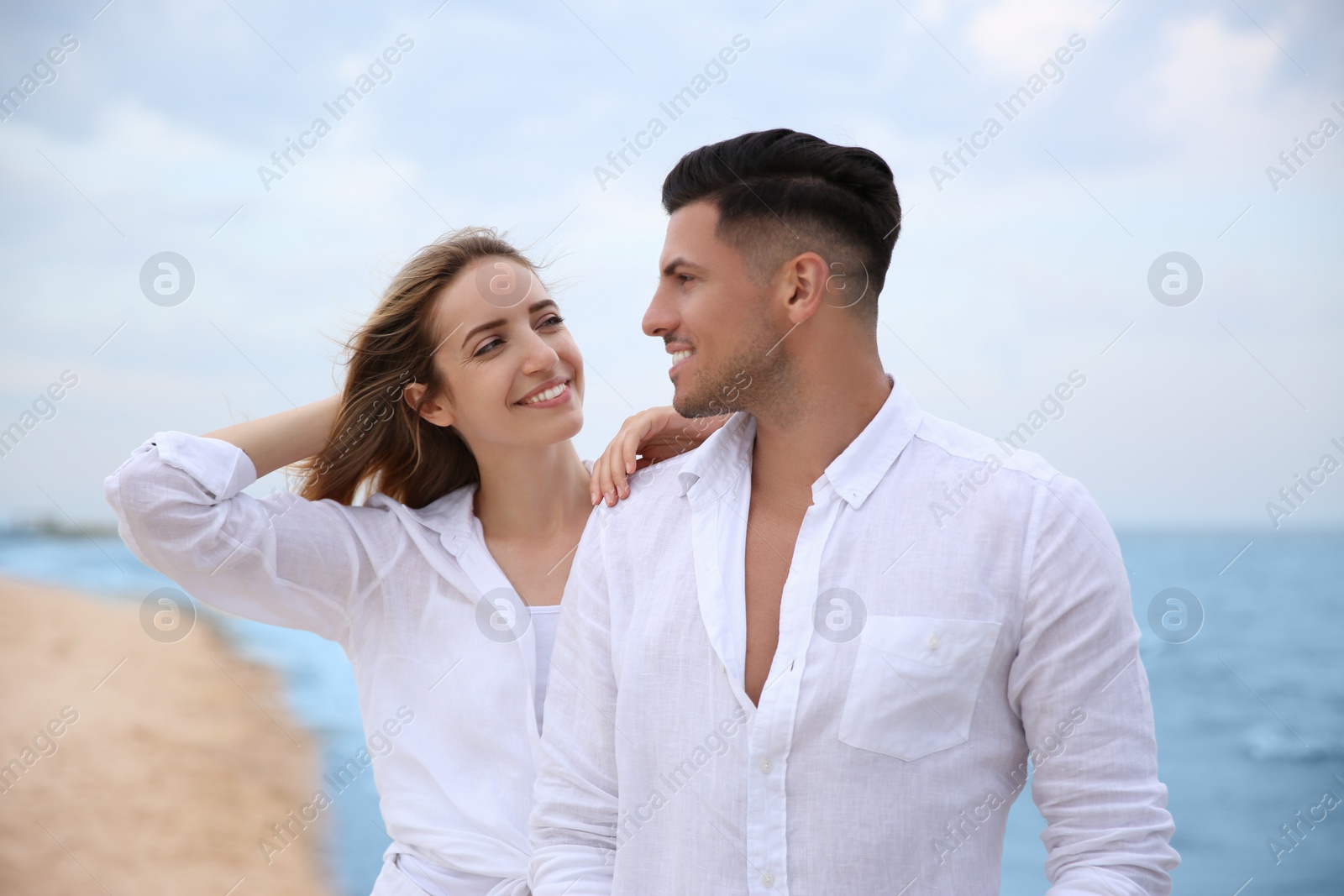 Photo of Happy couple having romantic walk on beach