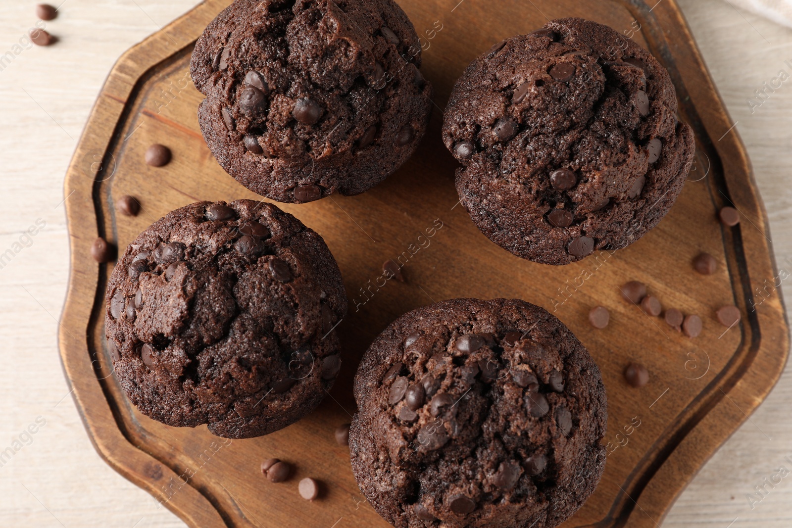 Photo of Delicious chocolate muffins on white wooden table, top view