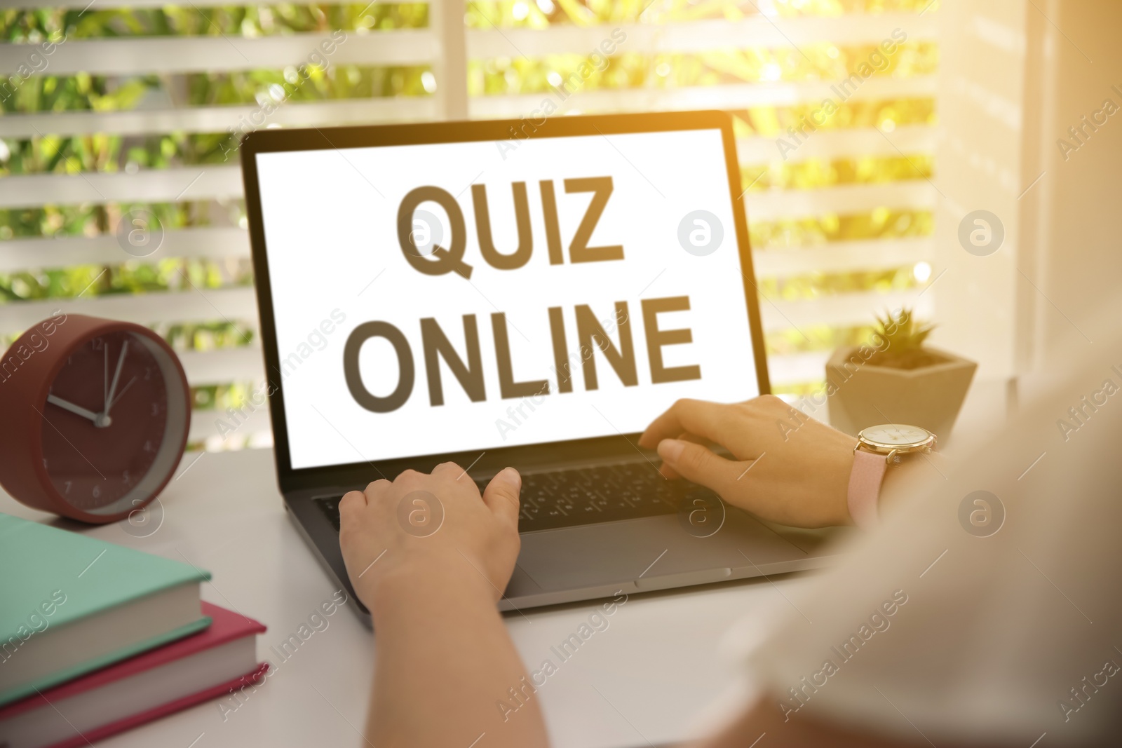 Image of Woman using modern laptop for taking quiz online at table, closeup