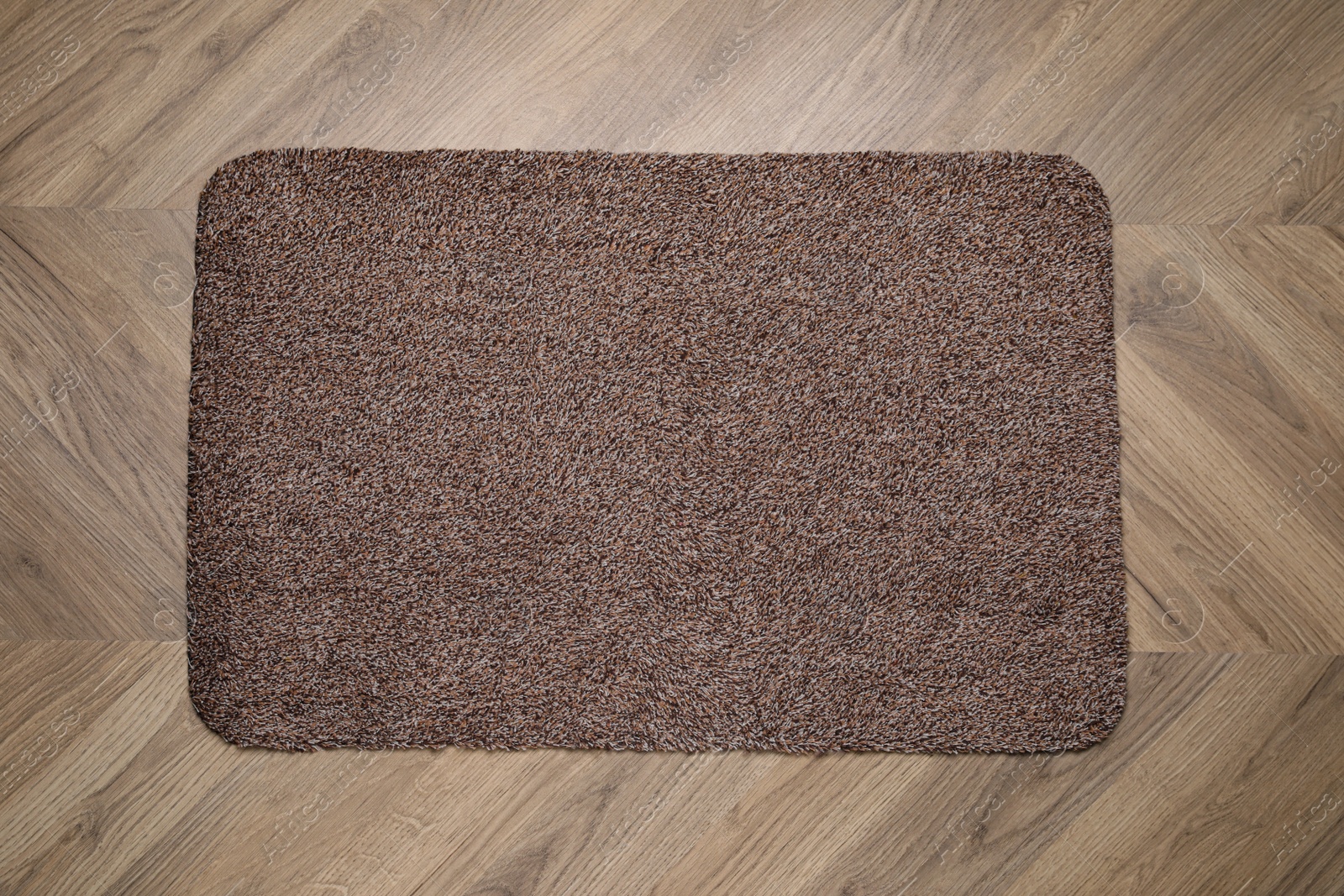 Photo of Stylish door mat on wooden floor, top view